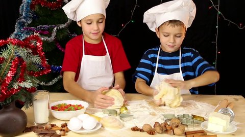Two kids kneading the Christmas dough together