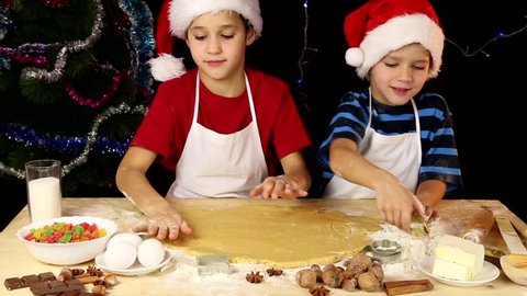 Two kids cutting the Christmas dough together