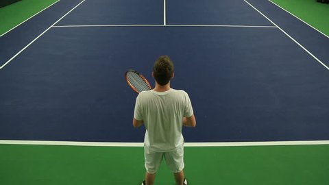 Young man practicing his Tennis skills at an indoor court 