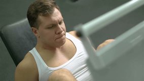 The above-view of a sportive guy being concentrated on leg exercises