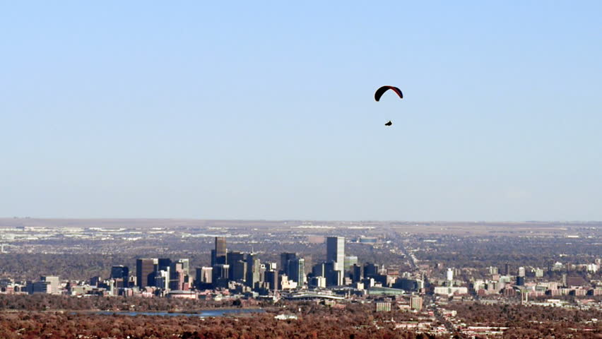 A paraglider sails across the sky over downtown Denver, Colorado. HD 1080p