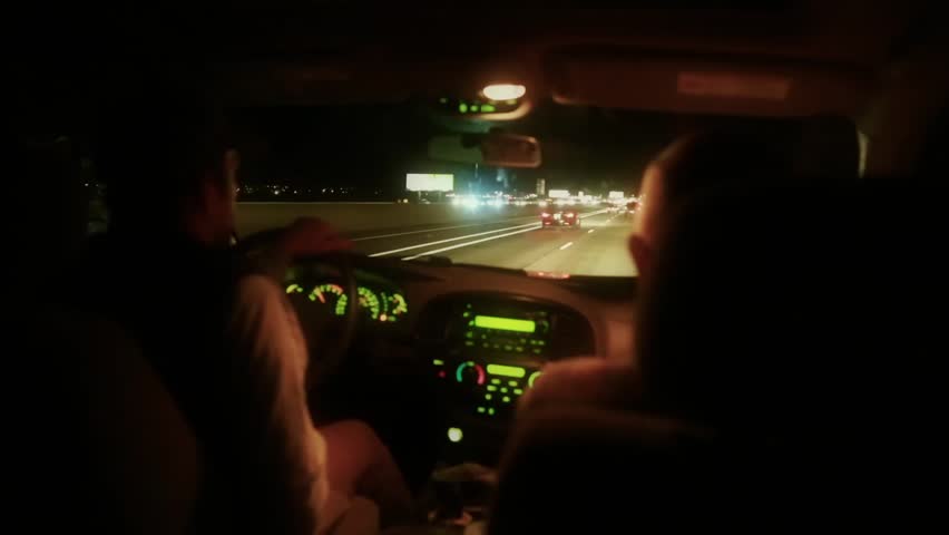 Men driving an SUV down the highway at night