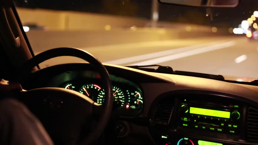Men driving an SUV down the highway at night