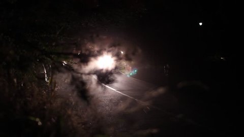 Rally start in the night. Race car with headlights on passing by 