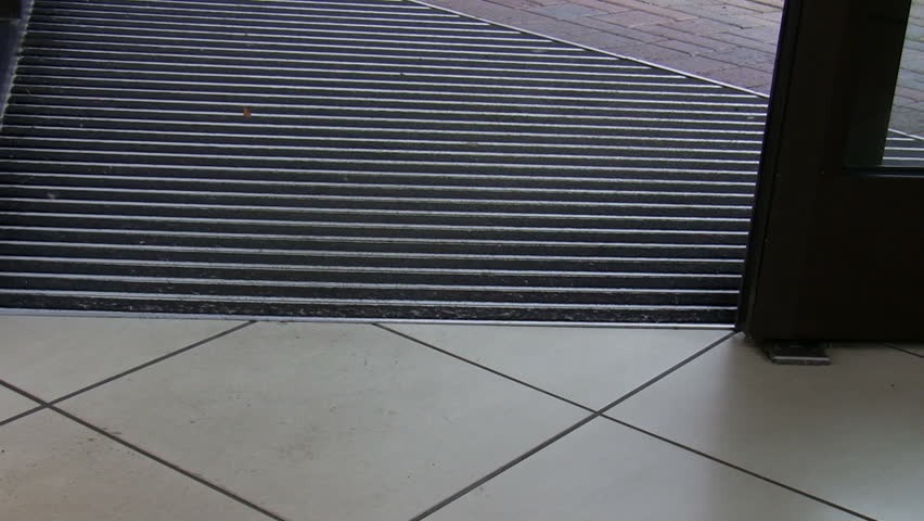 Handheld shot of closing sliding door of the trade building entrance