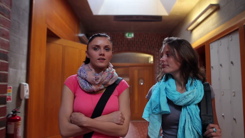Two pretty students walking down hallway to locker in college | Shutterstock HD Video #5058848
