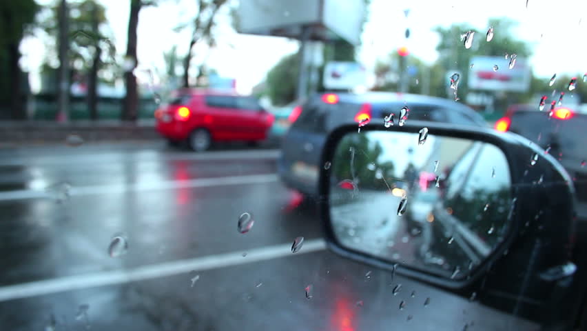 Rear view mirror time lapse, rainy weather, cars pass, stop
