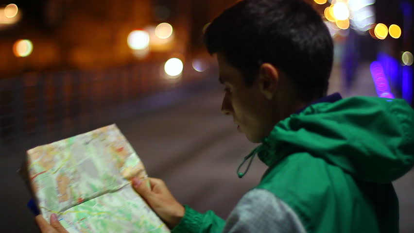 Tourist searching place location in map, lost in city night