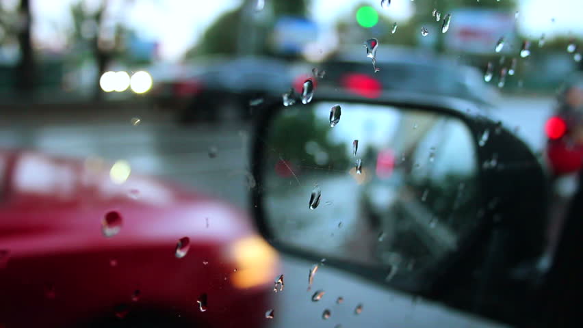 Side rear view mirror rainy weather, wet cars road city