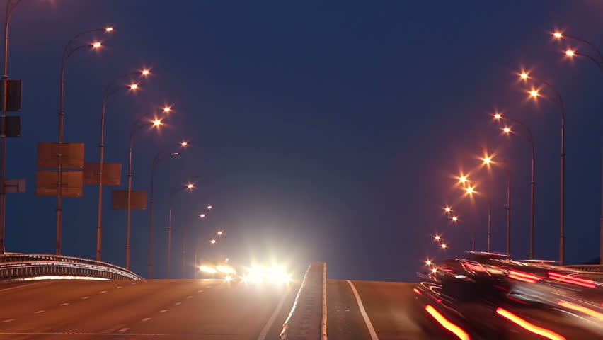 Timelapse of bridge highway traffic, dusk cars drive lights on