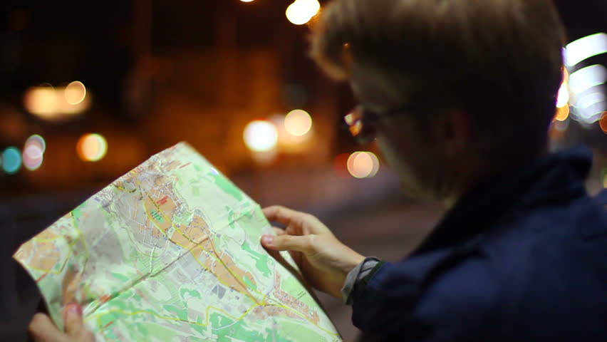 Male looking for route in tourist map foreign city night