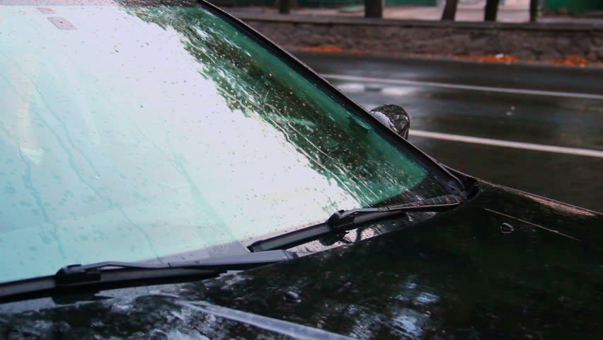 Raining on car front glass, windscreen wipers work, day rain