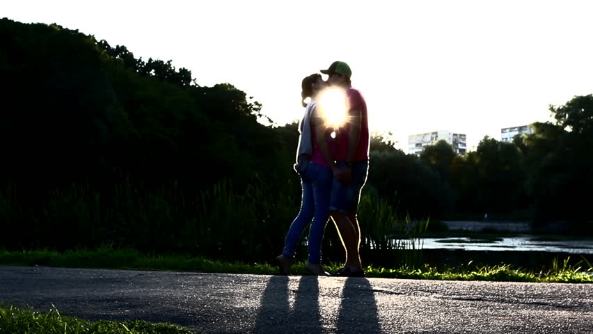 Silhouette of young couple kissing at sunset, romantic love