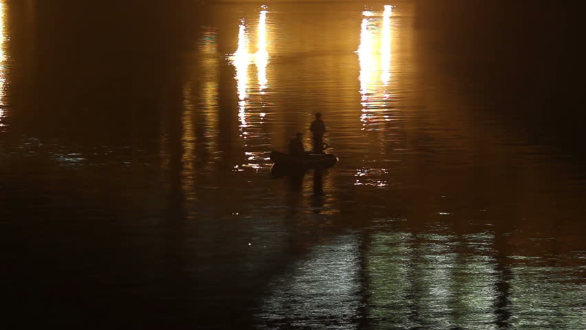 Fishermen boat night timelapse city yellow lights in water shine