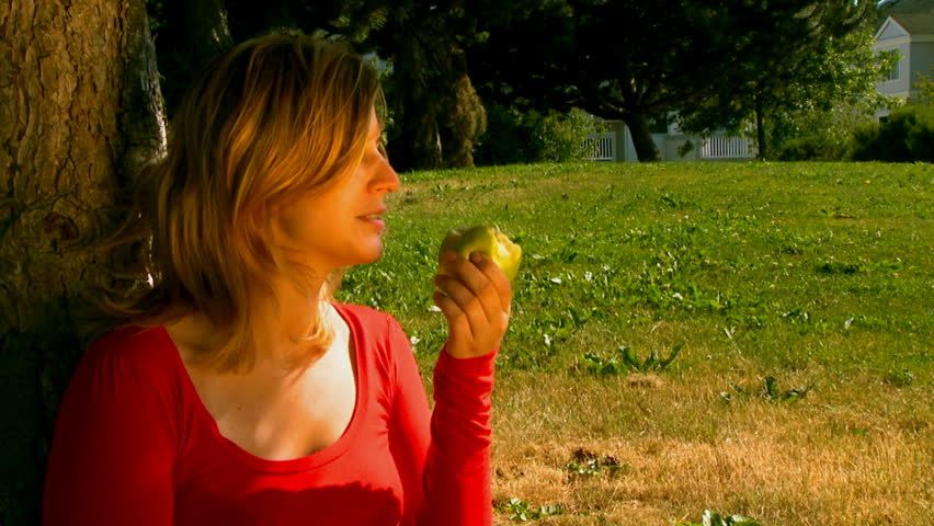 woman eating an apple outdoors