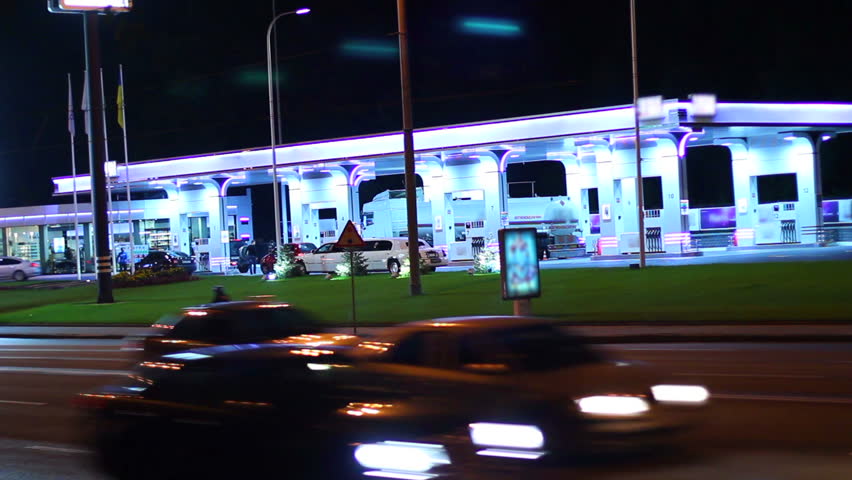 Gas station at night, contemporary petrol service cars drive in
