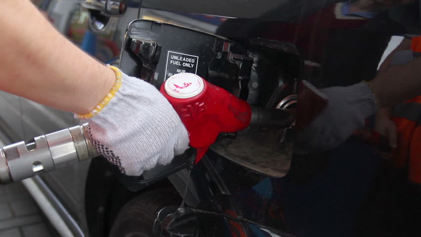 Fueling station service man glove pulls out pistol car gas