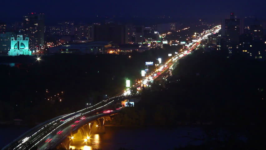 Nightlife city timelapse, cars moving across river bridge lights