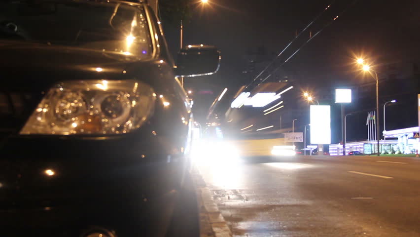 Night city traffic, cars pass by, bright lights shine timelapse
