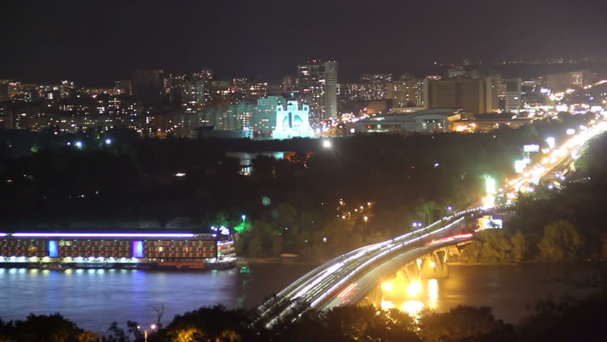 Colorful night city scape bridge over river, ferry cars drive