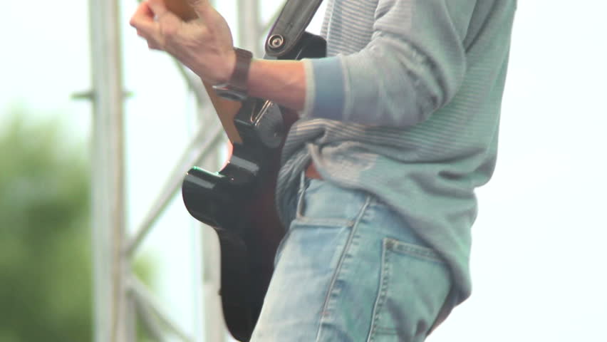 Man on stage playing guitar rocks audience, soft hard rock