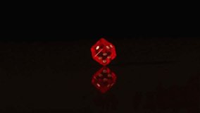 Red plastic dice revolving on black background in slow motion - Powered by Shutterstock - Get 15% off with code: PIKWIZARD15