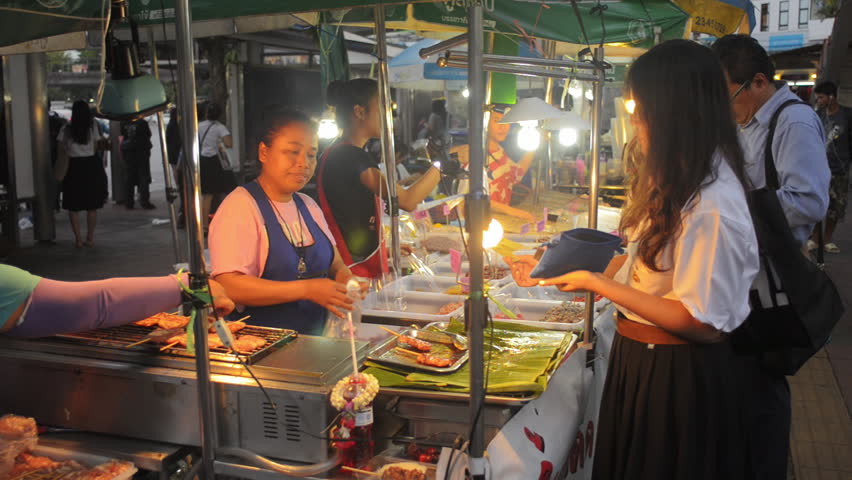 BANGKOK, THAILAND - NOVEMBER 2013: A street vendor selling grilled pork on a