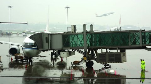 passengers walking on boarding bridge at airport jetway