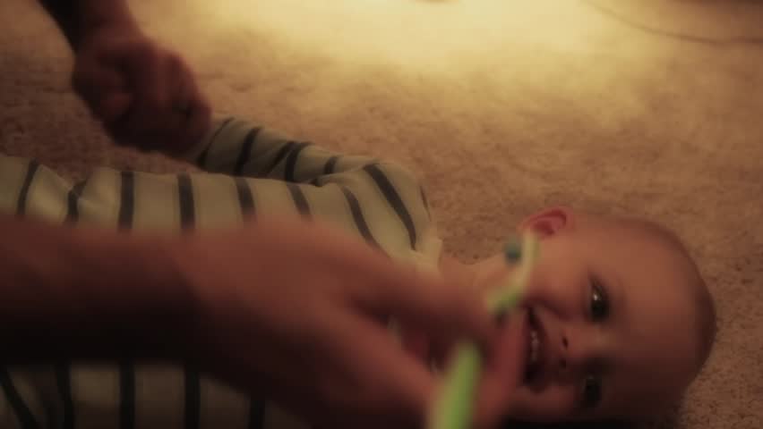A father brushing his toddler boys teeth and getting him ready for bed