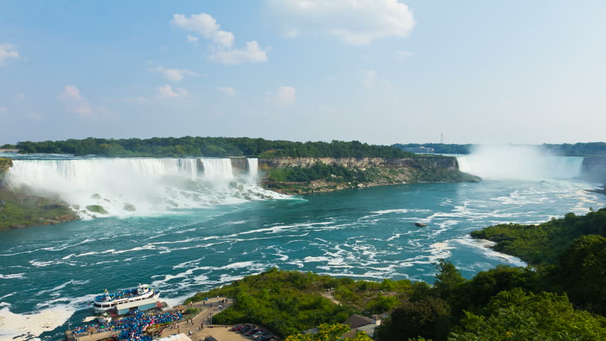 Time lapse of Niagara Falls. Time lapse of boats and people in and around Niagara Falls looking into the United States side. Loading and unloading of Maid of the Mist boat tour at bottom left. 