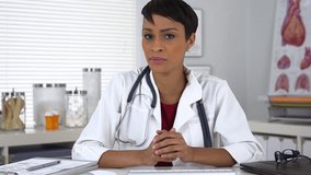 Black doctor talking to the camera and taking notes