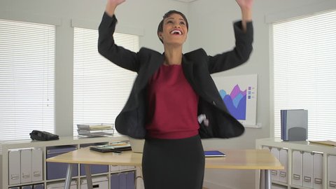 Happy African American business woman jumping and celebrating