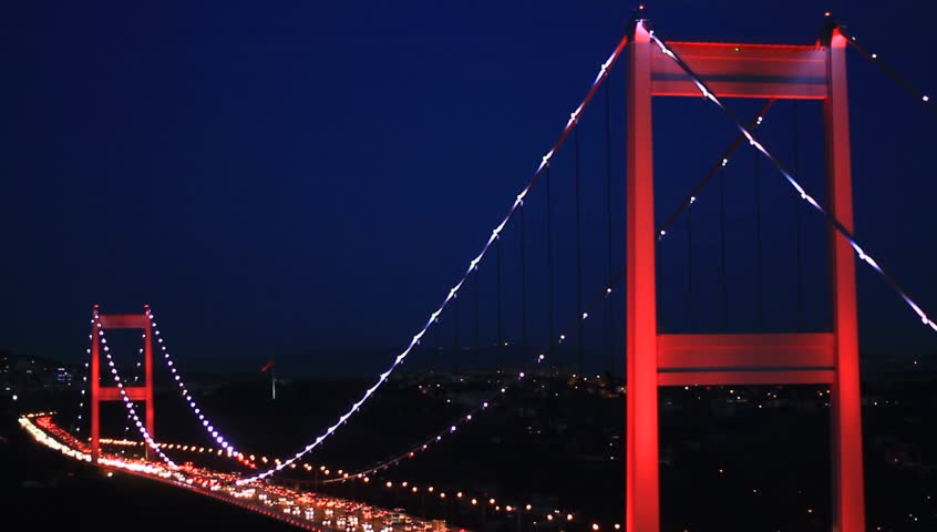 Suspended bridge with red lighting at night in Istanbul, Turkey. FSM Bridge with