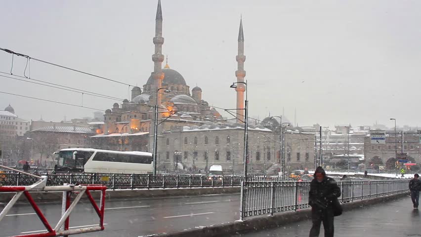 ISTANBUL - JAN 31: Galata Bridge and Yeni Mosque in the snow rain on Jan 31,