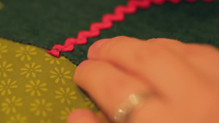 A woman sewing a Christmas advent calendar in her home