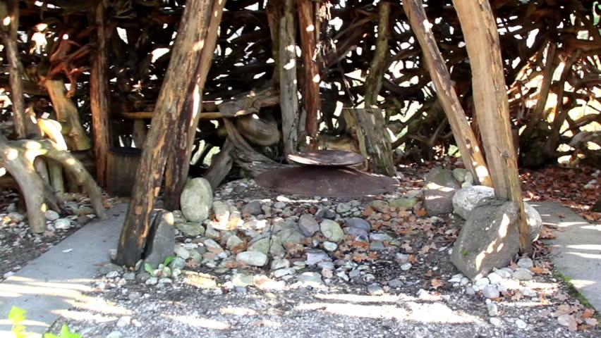 Wooden sticks and some big roots surrounding the fireplace found inside the small witch house hut made out of big roots.