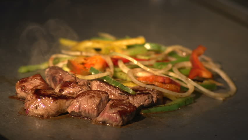 Meat and vegetables on grill - slow motion shot