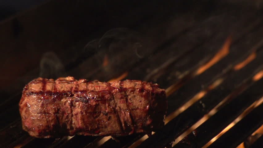 Steak on grill - slow motion shot