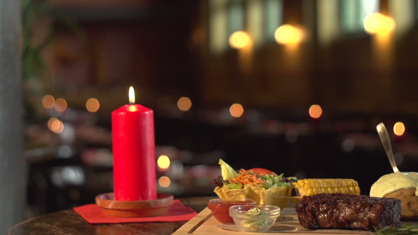 Steak and vegetables on plate, decorated with a candle