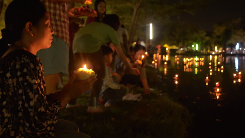 BANGKOK, THAILAND - NOVEMBER 17, 2013:  A Thai woman kneels and prays, before