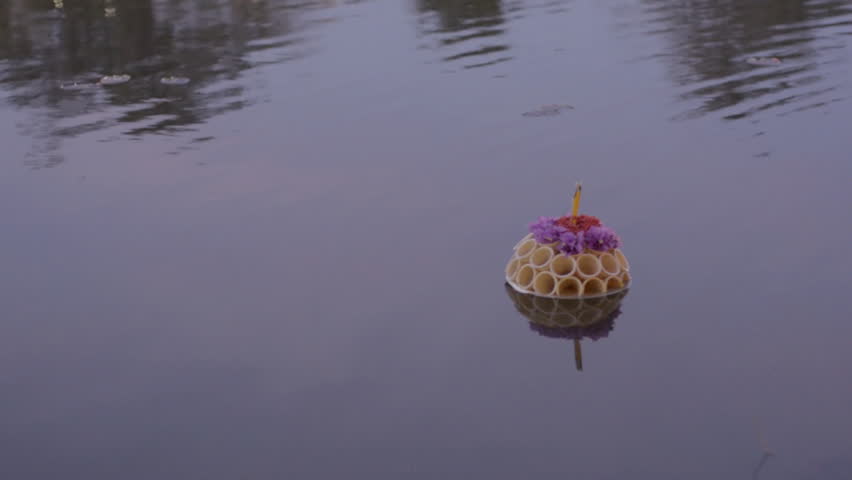 A krathong float made of ice cream cones floating by at dusk during the Loi