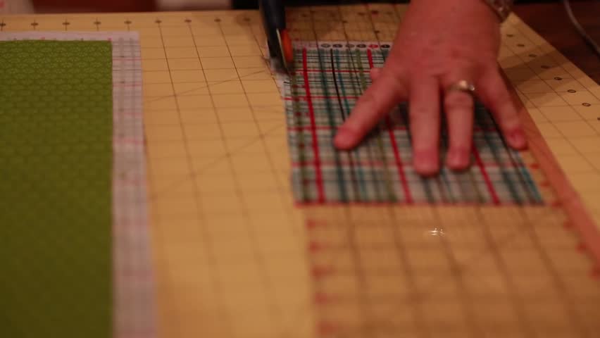 A woman cuts cotton fabric for a christmas advent calendar