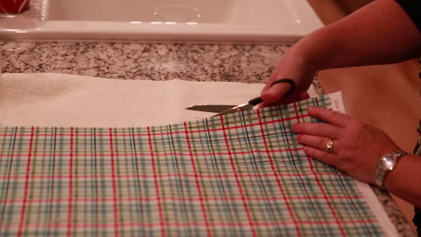 A woman cuts cotton fabric for a christmas advent calendar