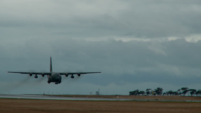 A C130 hercules makes a low approach before climbing for a departure