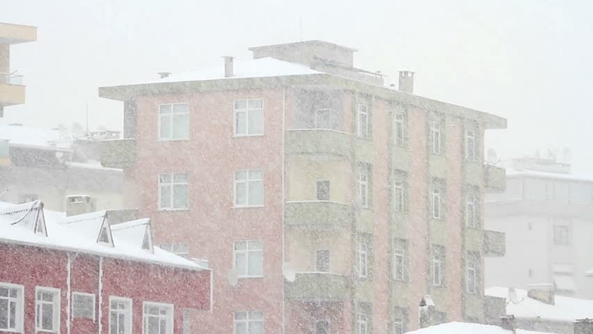 Snow in city. Tilt Video. Snow falling in front of the living block of flats