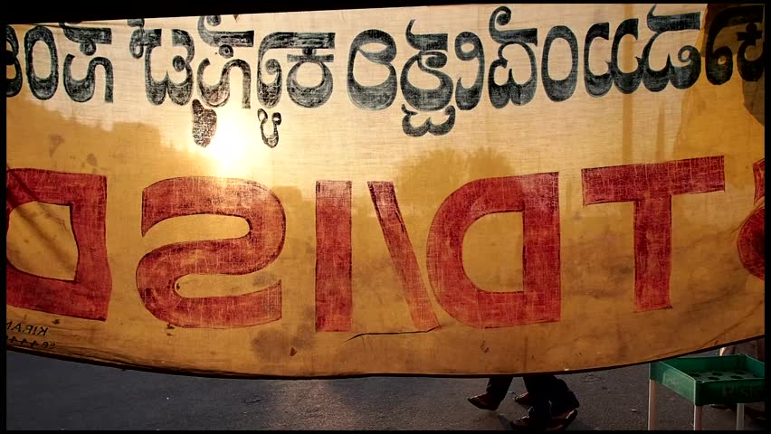 Group of people walking next to a banner during dusk, Mysore, India