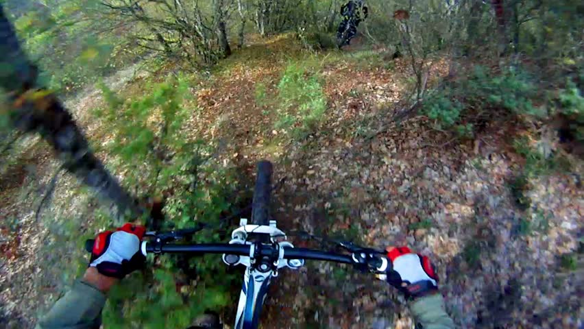 Extreme Mountain Bike race. View from handlebars of man on bike on dirt track pov