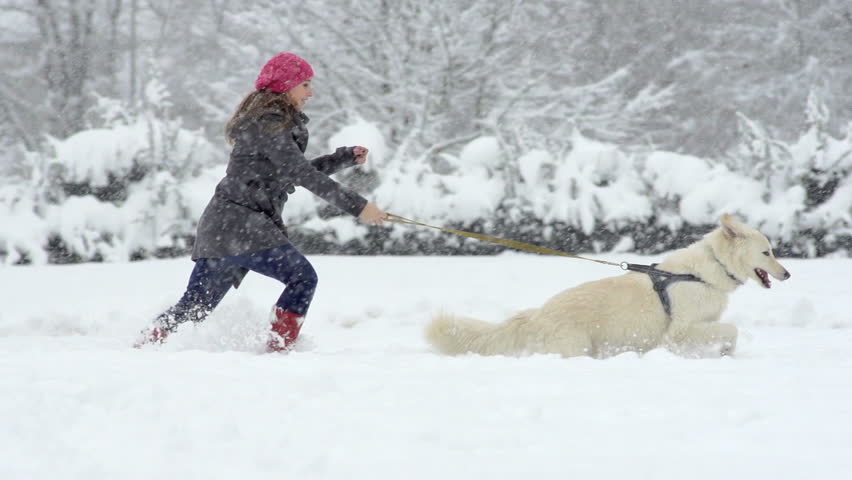 Slow Motion Of A Young Woman Running Through Fresh Snow With Her Beautiful White