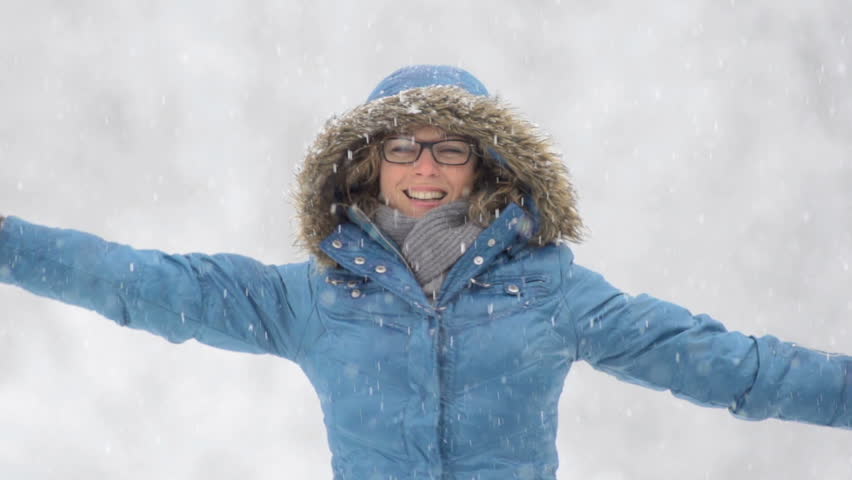 Slow Motion Of Young Woman Turning Around With Her Arms Stretched Out On A Snowy Winter Day.