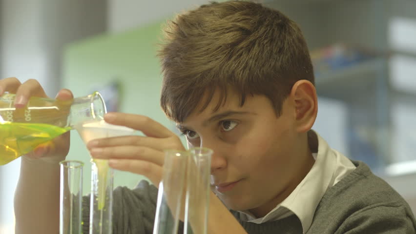 CU Schoolboy pouring chemical into test tube in laboratory | Shutterstock HD Video #5100182